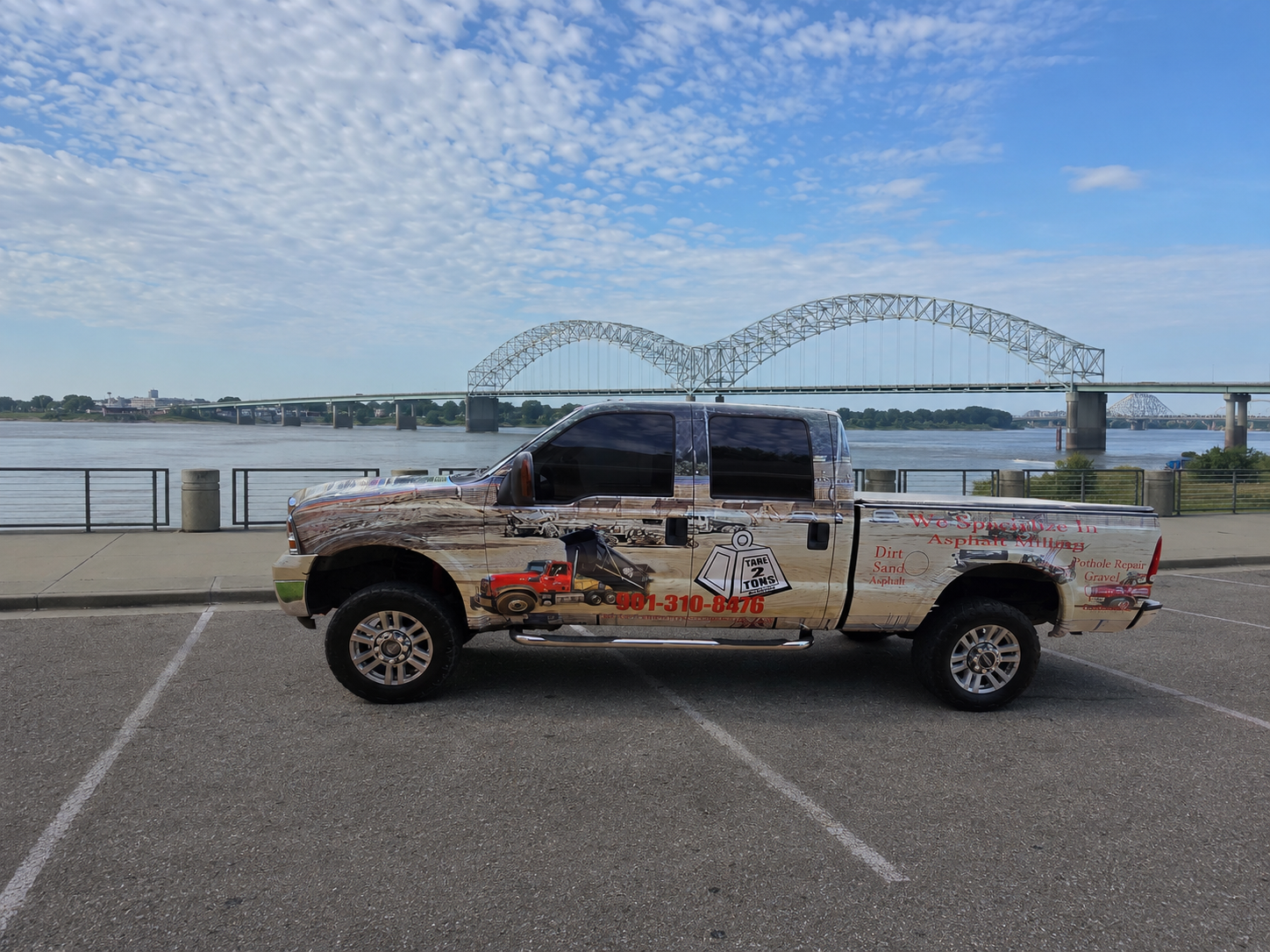 Tare 2 Tons Xpress advertising pickup beside the Mississippi River and Memphis Hernando de Soto Bridge
