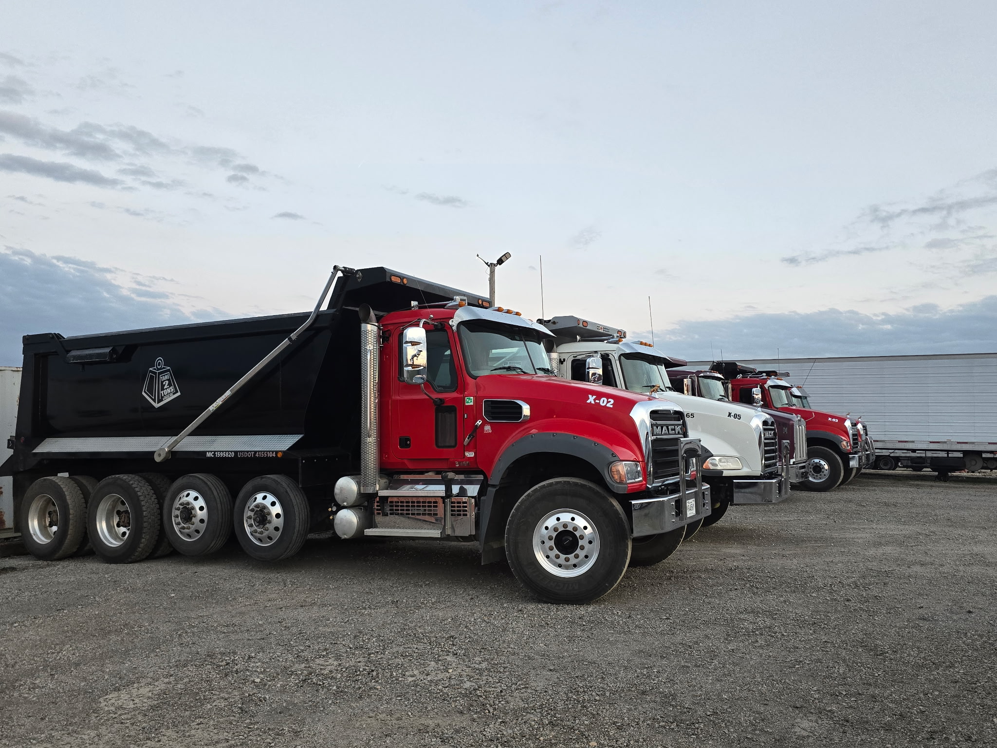 Tare 2 Tons Xpress dump truck fleet lined up at the yard