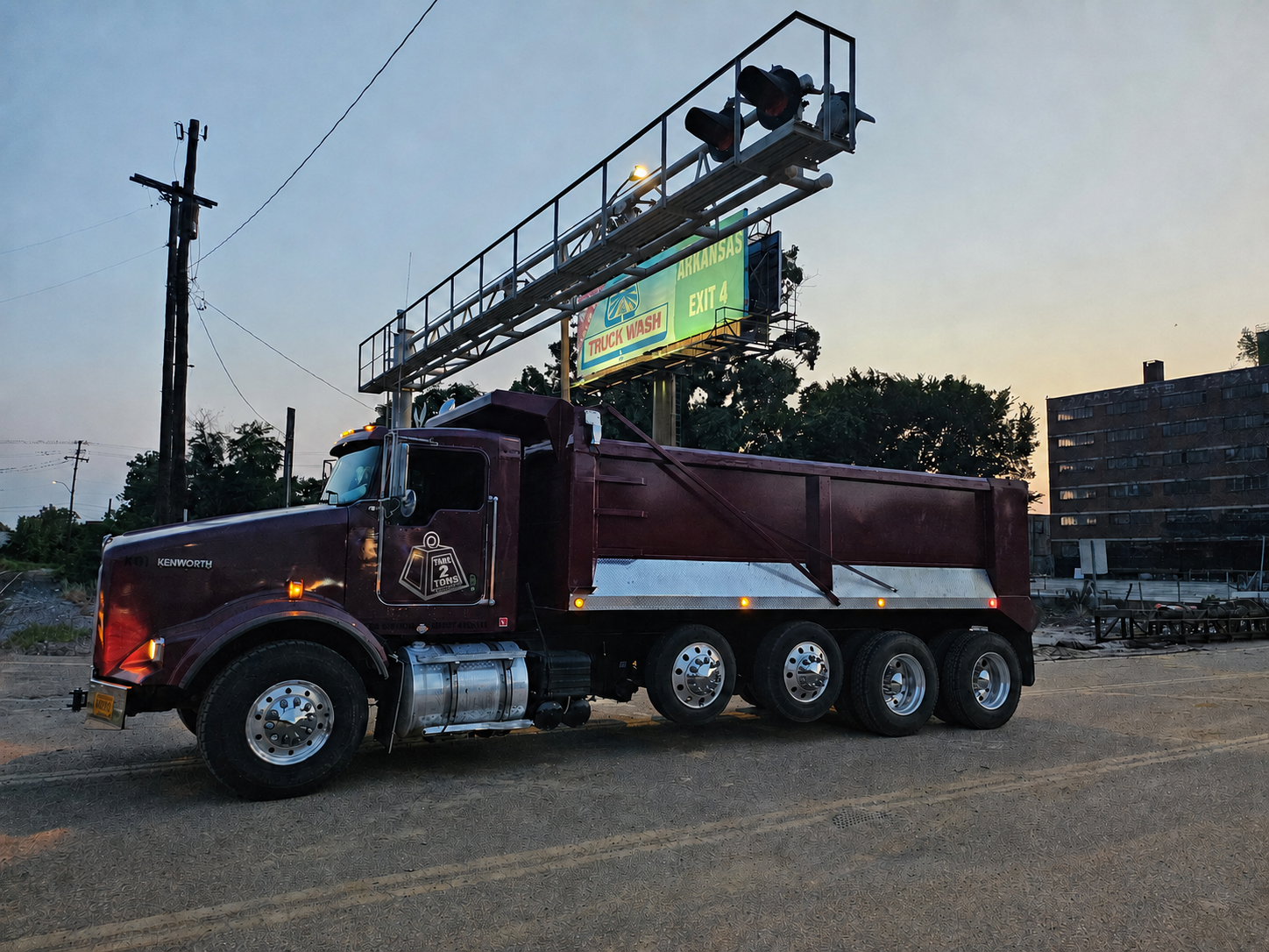 Maroon Tare 2 Tons Xpress quad-axle dump truck at a job site