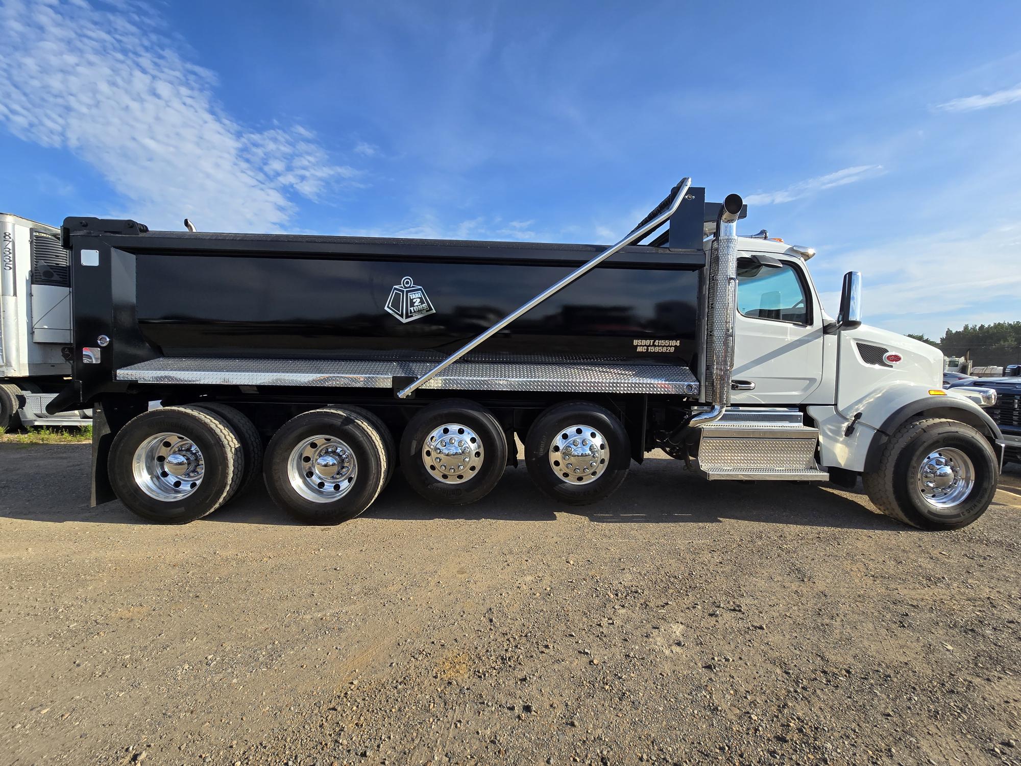 Side view of a Tare 2 Tons Xpress quad-axle dump truck